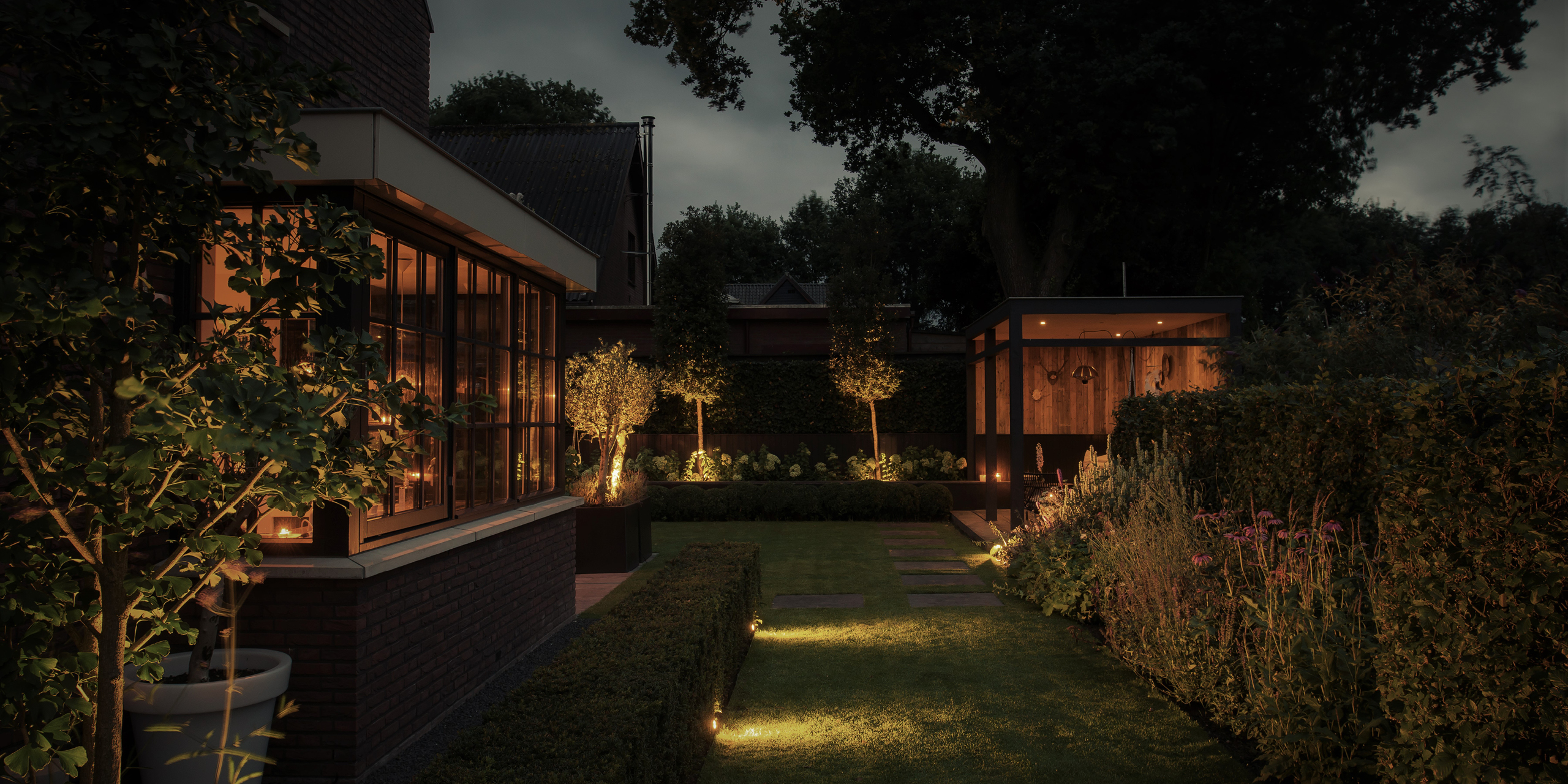 Buytengewoon leeftuin in Elspeet met veranda, steeneiken, tuinverlichting en echinacea.