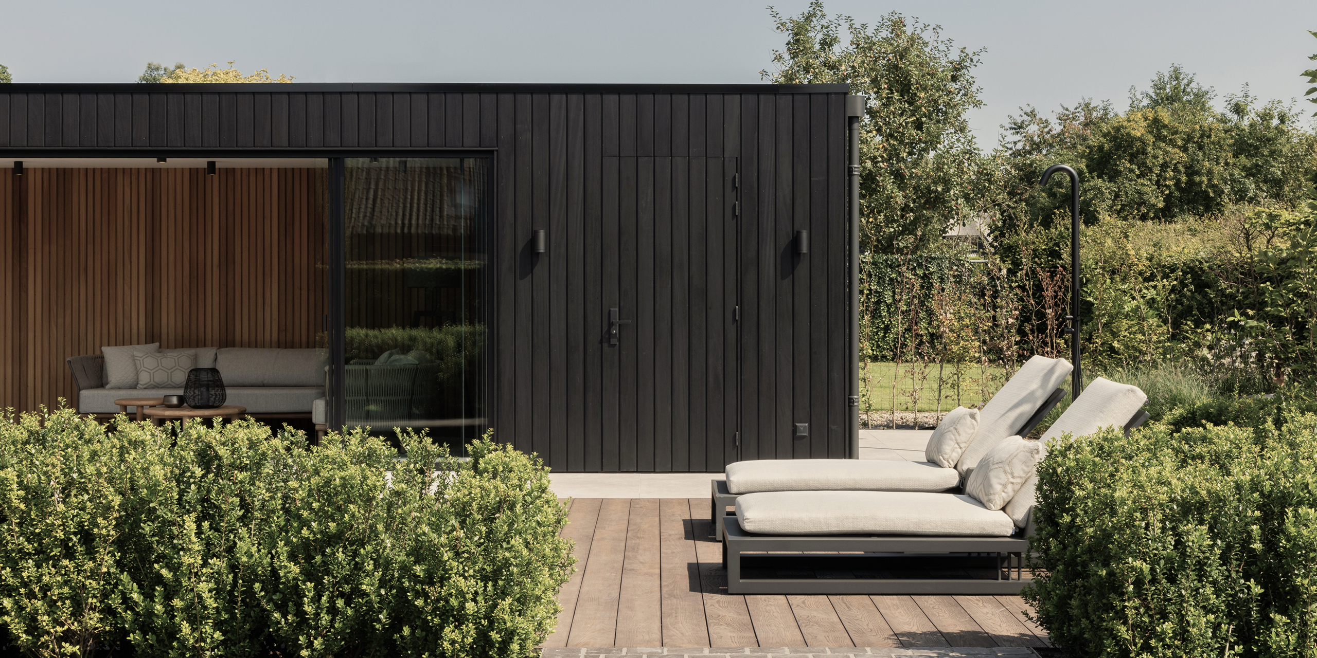 Buytengewoon tuin in Uddel met poolhouse, buitendouche en ligstoelen.