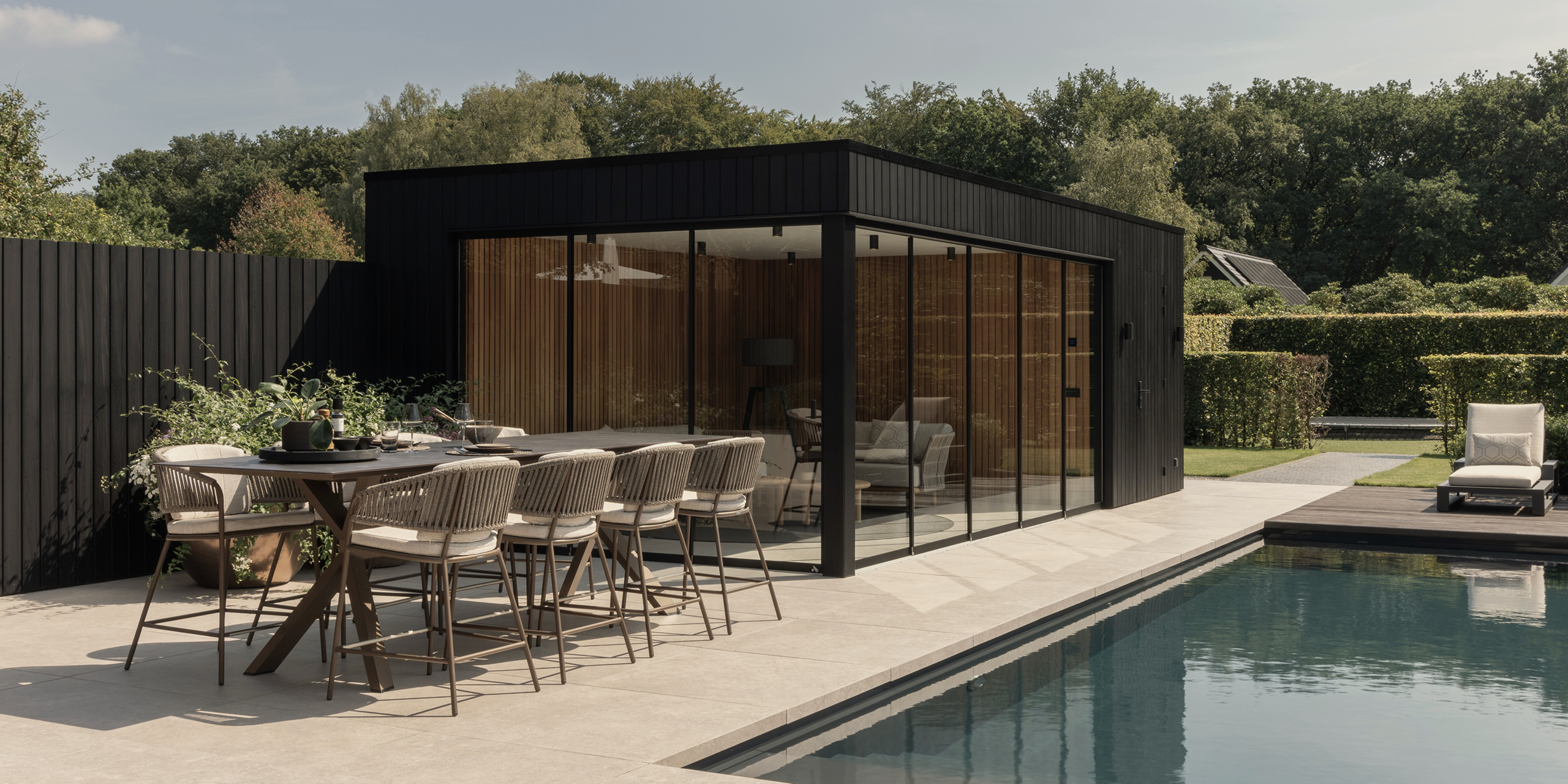Buytengewoon tuin in Uddel met terras, poolhouse, zwembad en tuintafel.
