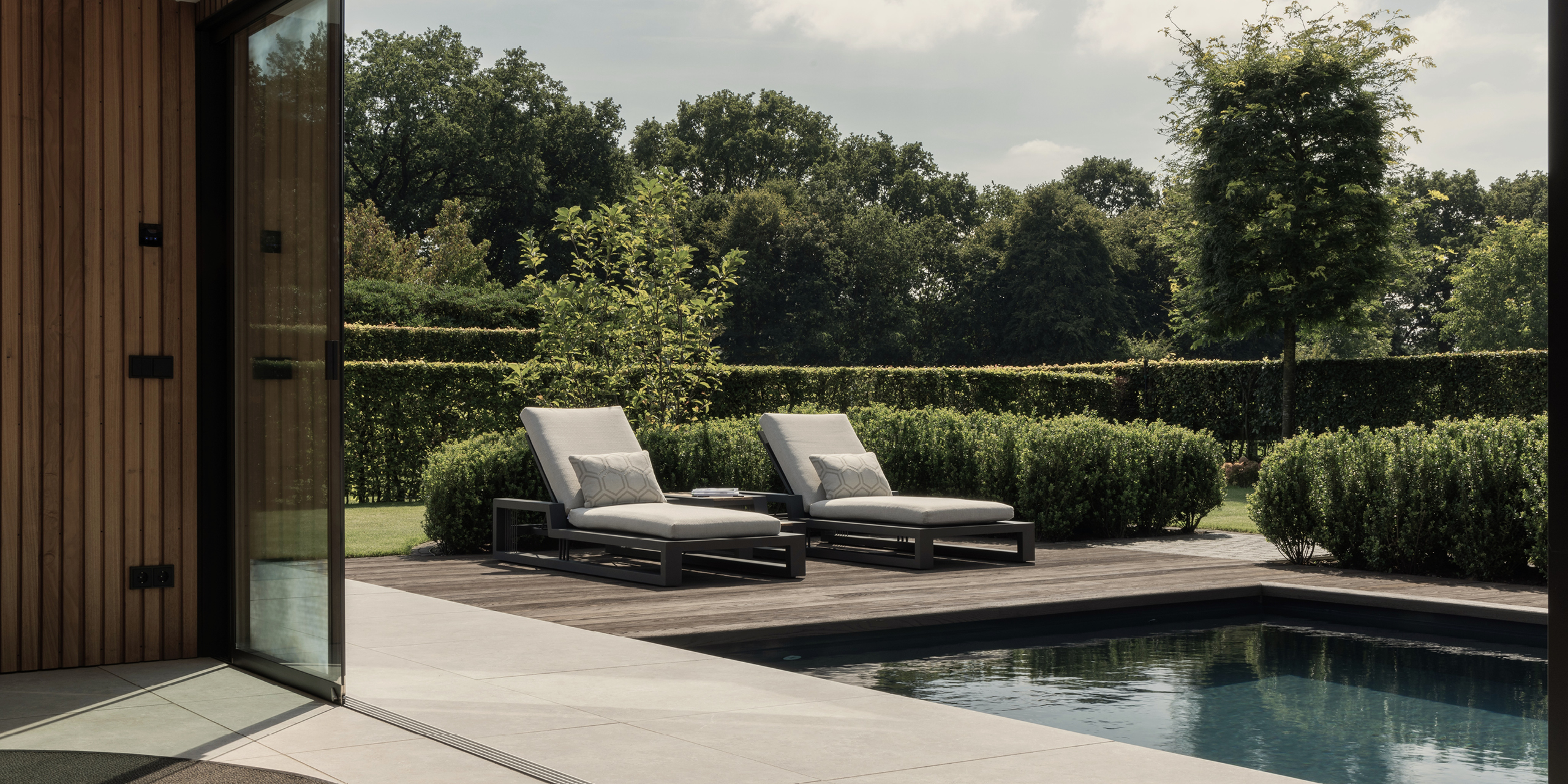 Buytengewoon tuin in Uddel met zwembad, vlonder en ligstoelen.