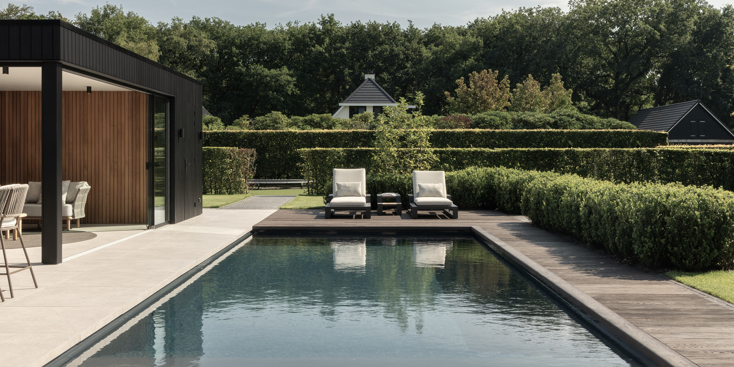 Buytengewoon tuin in Uddel met zwembad, terras, vlonder, ligstoelen en gazon.