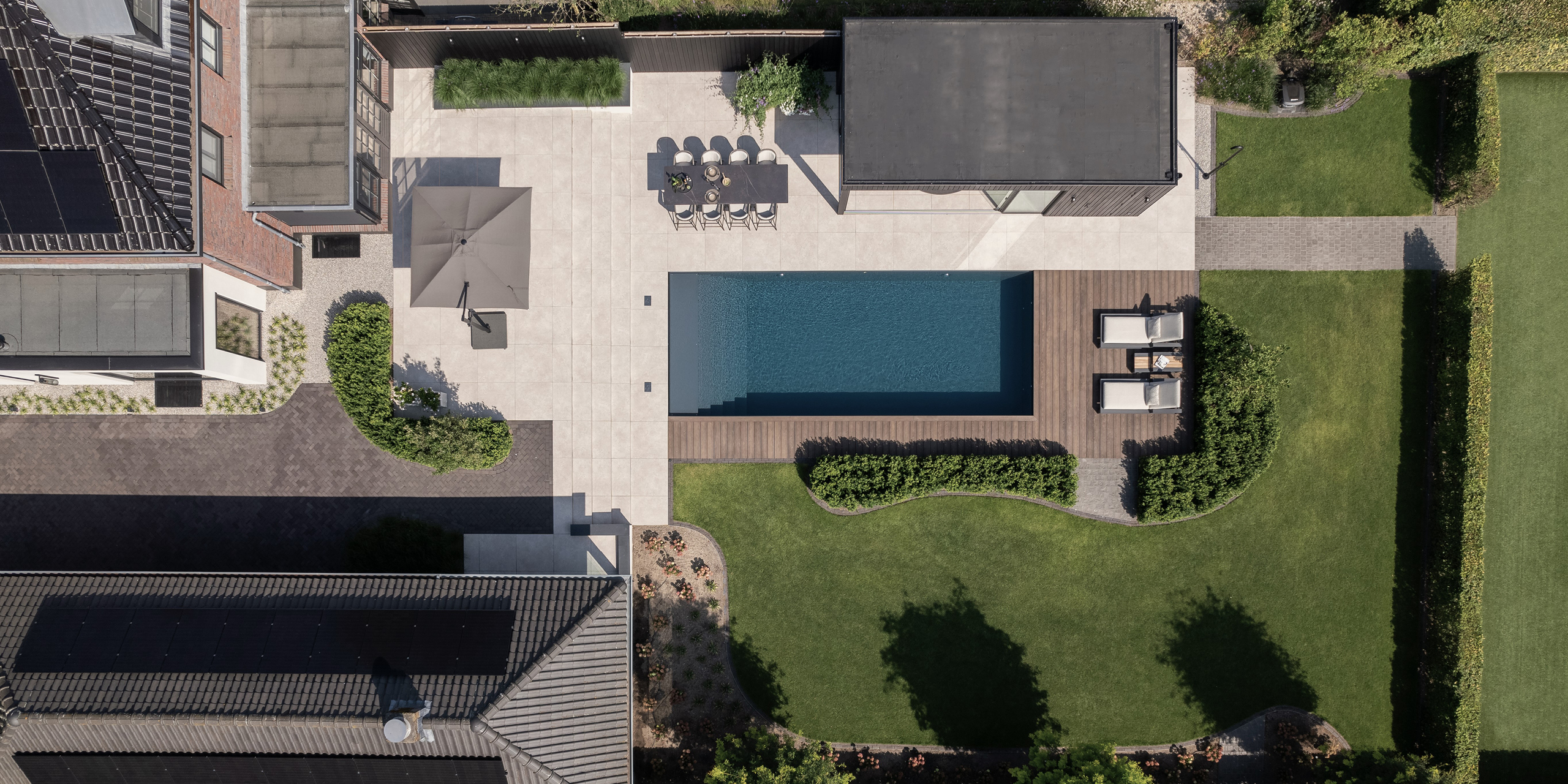 Buytengewoon tuin in Uddel met gazon, schuur, poolhouse, zwembad, tuintafel, vlonder, beukenhagen en ligstoelen.