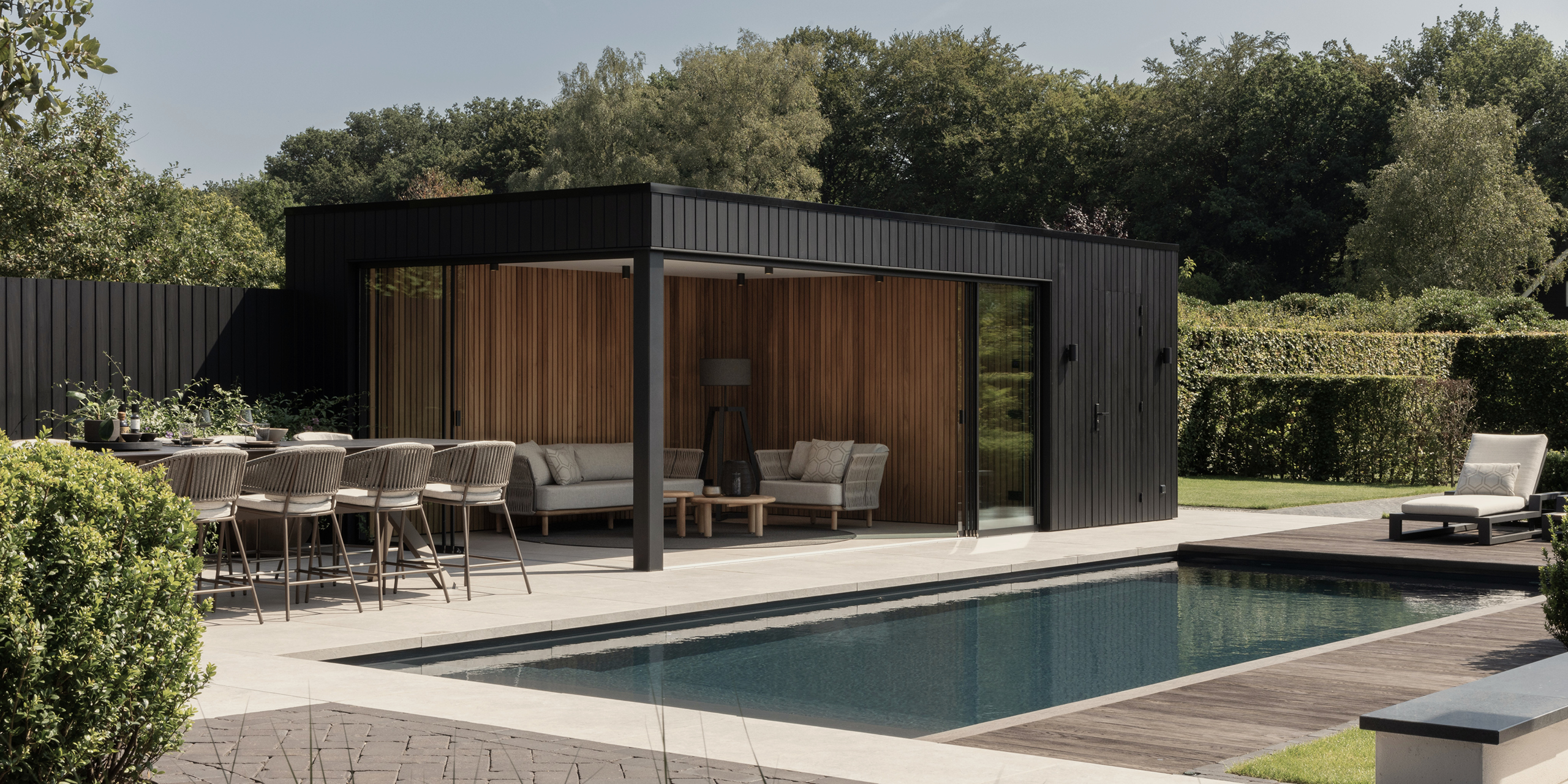 Buytengewoon tuin in Uddel met poolhouse, tuintafel, zwembad en beukenhagen.